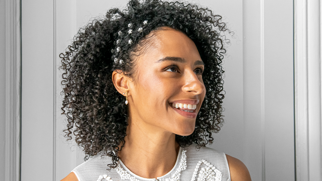 Woman with black, curly hair, styled for a wedding